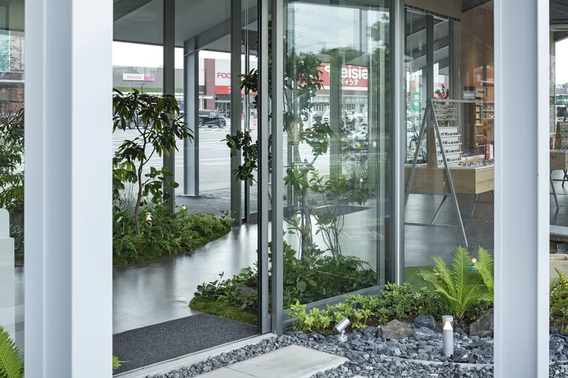 Interior planted beds with glass partitions and pebble ground cover beneath exposed structural ceiling