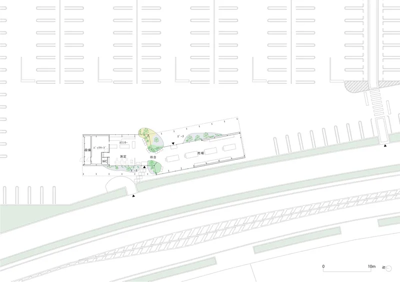 Site plan drawing showing angled building footprint between parking lots and diagonal railway tracks