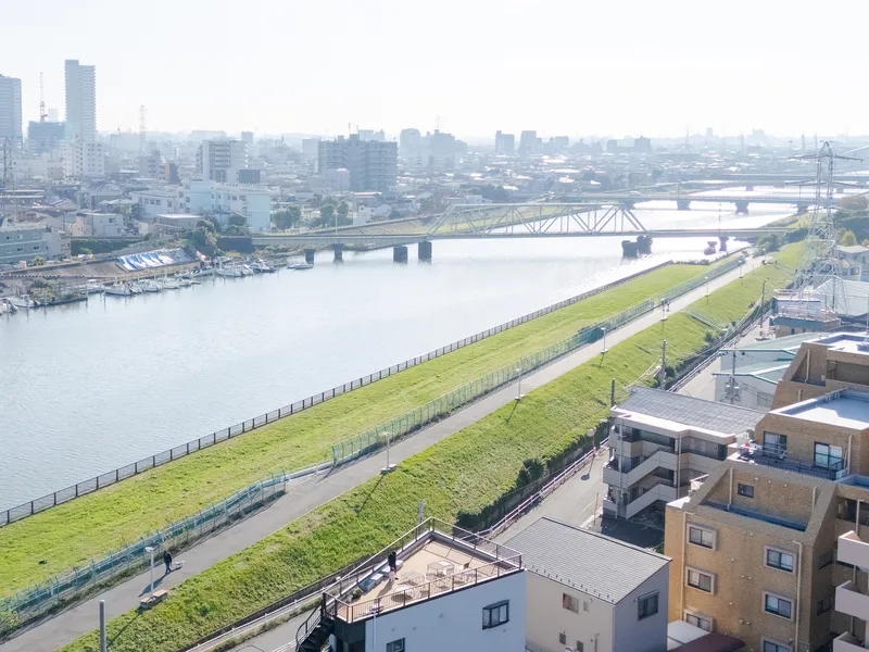Elevated view of the sloped green embankment with a pedestrian path along the river