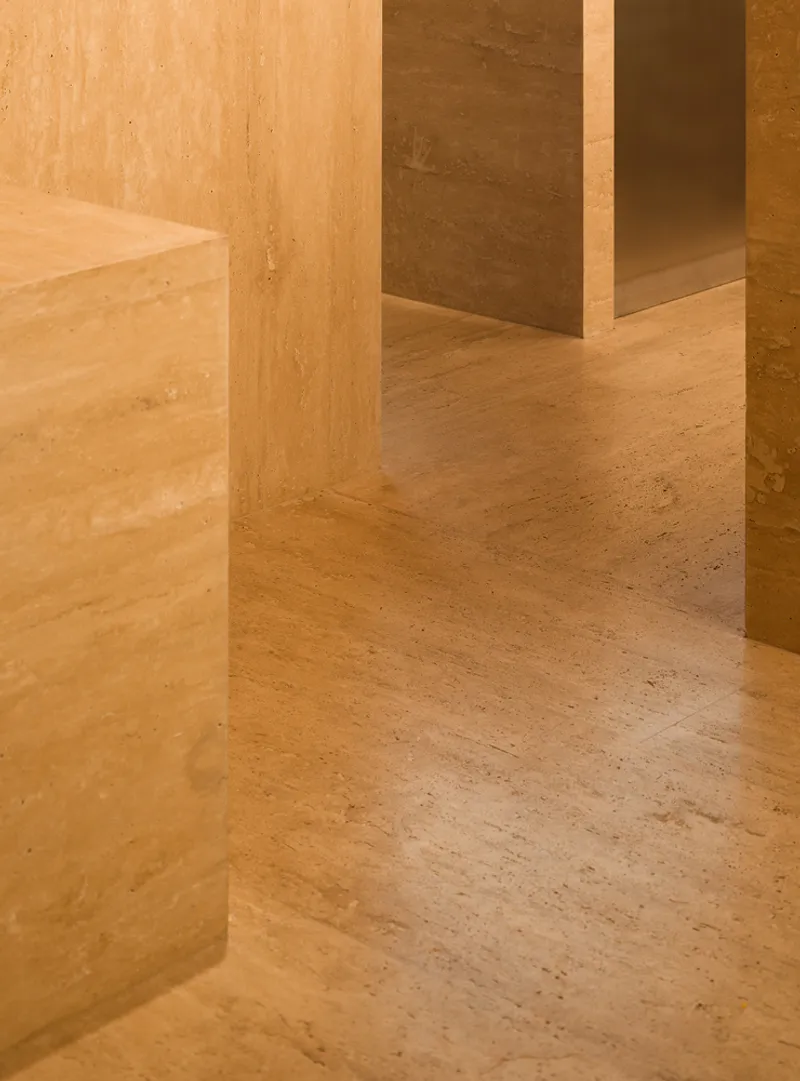 Timber volumes meeting terrazzo floor with natural light casting shadows across the surface
