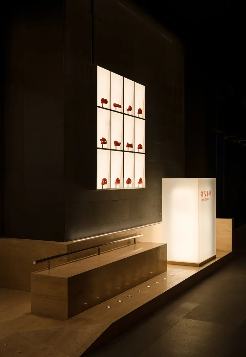 Interior entry counter and glowing display niche with timber bench beneath recessed floor lighting