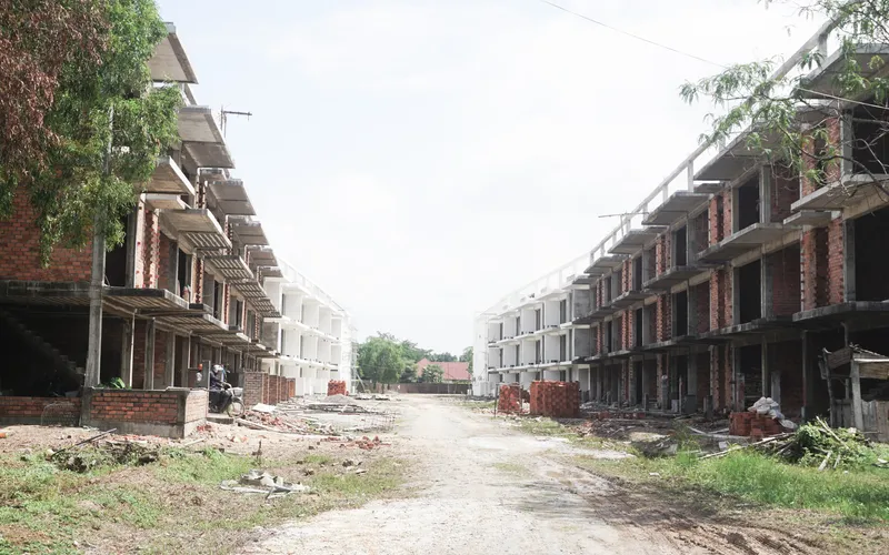 View down a construction street between two rows of unfinished brick residential blocks