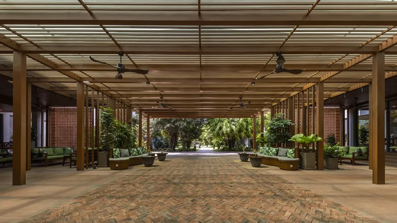Covered entrance lobby with timber slat ceiling, perforated screens, and herringbone brick paving