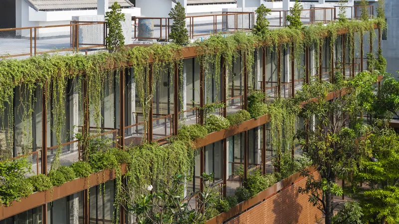 Tiered balconies with steel framing and trailing greenery between planted terraces