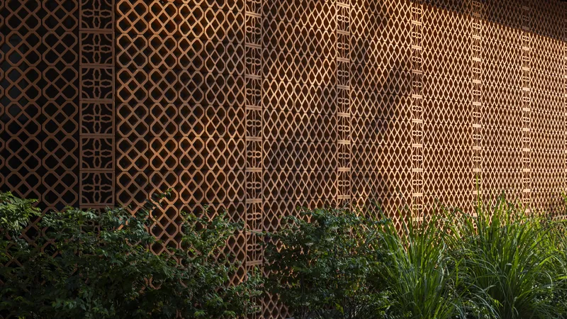 Decorative lattice wall panels with geometric diamond pattern above a planted bed at dusk
