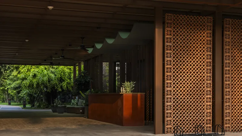Covered entry foyer with lattice screens, timber reception desk and view to landscaped garden