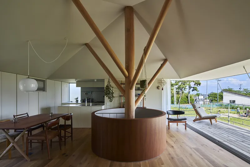 Open living area with exposed timber column and radiating rafters supporting the vaulted ceiling