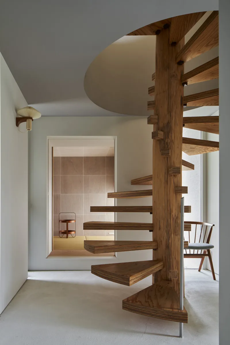 Spiral staircase with cantilevered timber treads wrapping around a central wooden column