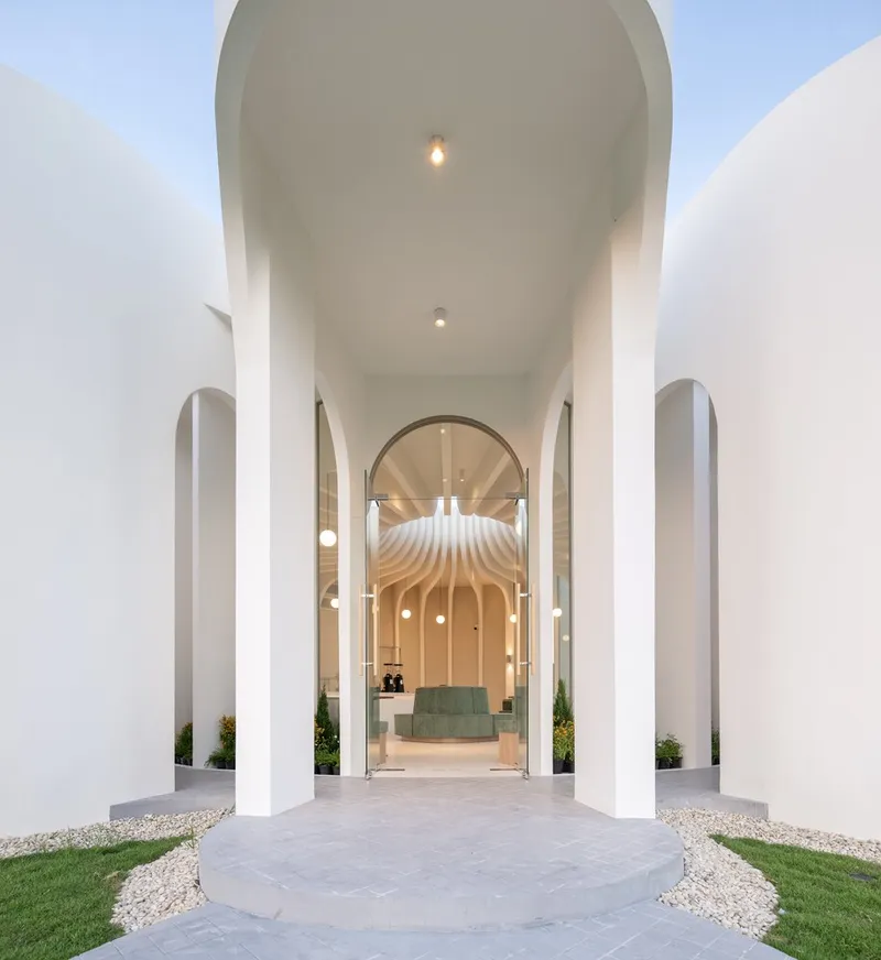 Entry portal framed by arched columns with view through to the sculpted interior ceiling