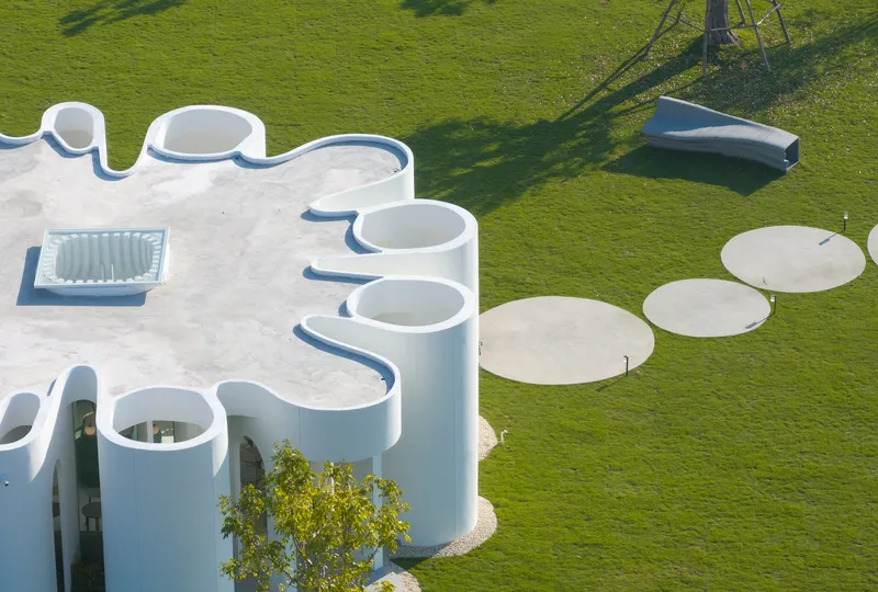 Overhead view showing the scalloped roof edge and circular concrete pads in the lawn