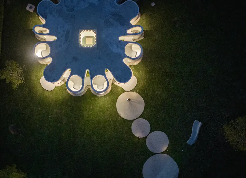 Drone view of the cloverleaf-shaped structure with circular terrace pads at dusk