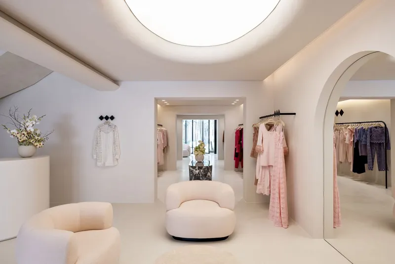 Retail gallery with circular ceiling skylight and arched openings connecting multiple display rooms