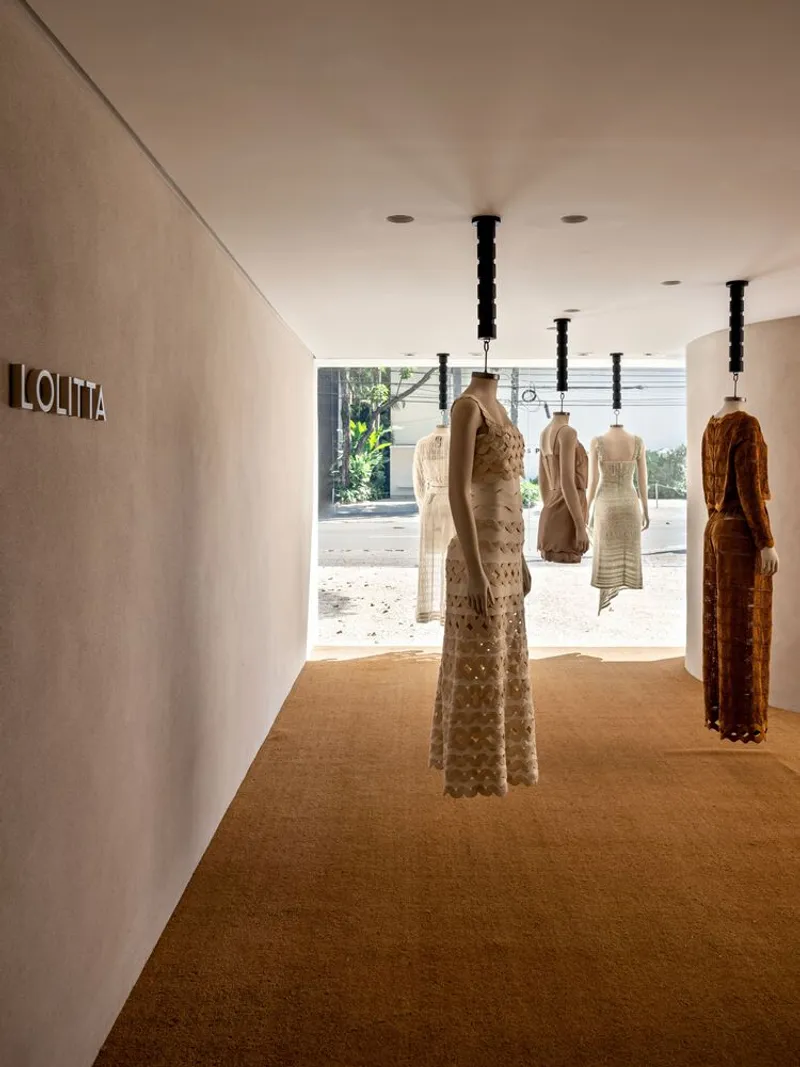 Cork flooring corridor with suspended dress forms on black pendant fixtures facing the glazed entrance