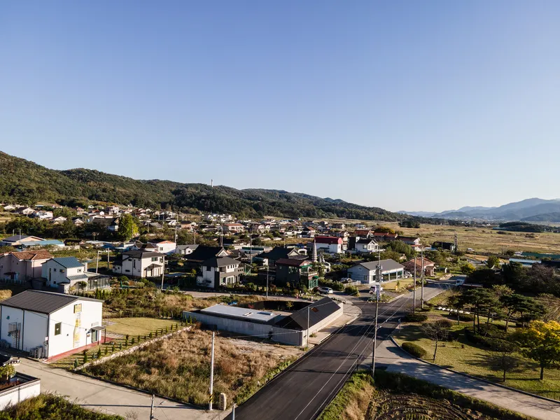 Aerial view of the house among neighboring buildings in a valley with distant hills