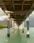 This architectural image showcases a wooden pier extending over calm, turquoise waters. The pier's s