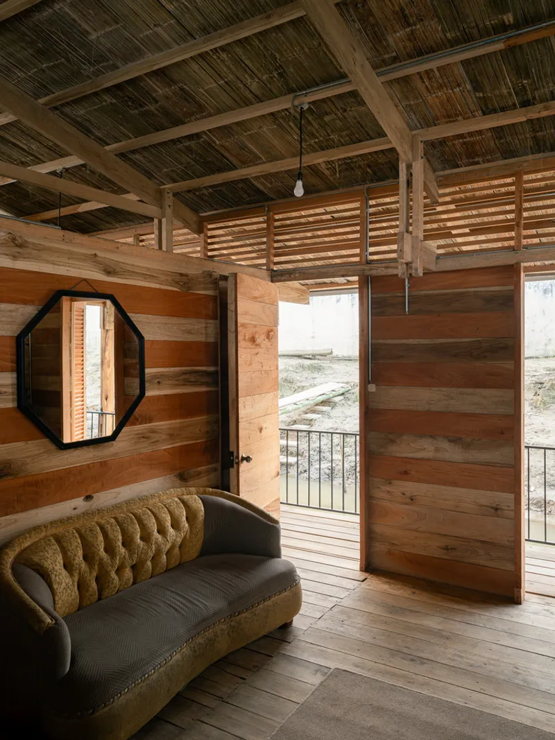 Interior room with horizontal wood plank walls, bamboo mat ceiling, and octagonal mirror beside doorway