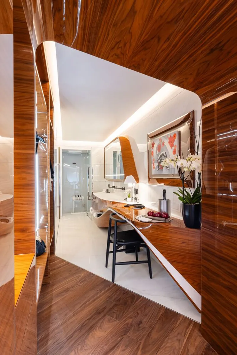 Bathroom vanity area framed by wood-clad walls and ceiling with indirect lighting along the edges