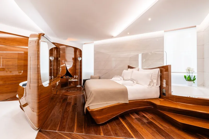 Bedroom suite with striped wood flooring, curved partition wall and backlit white ceiling plane