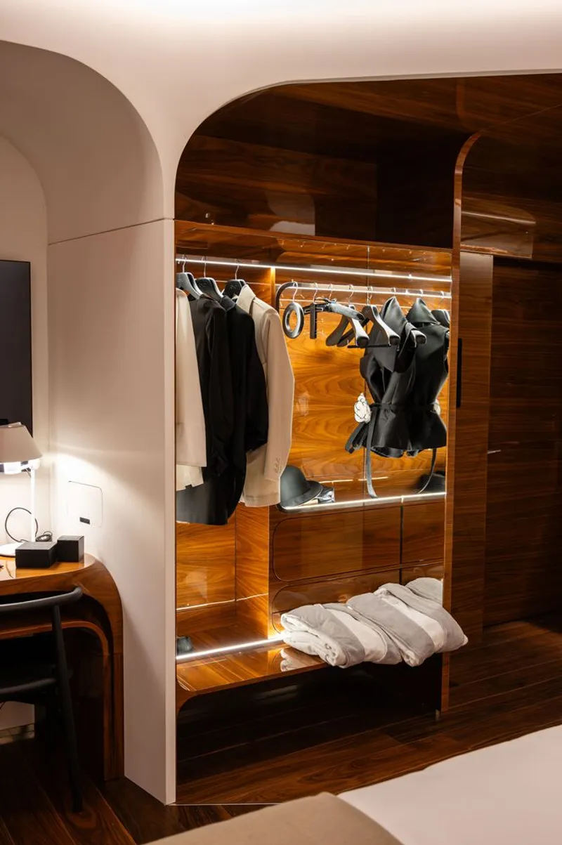 Built-in wardrobe niche with striped wood cladding and arched ceiling opening