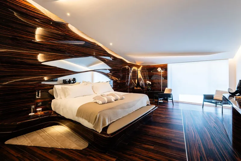 Platform bed against striped wood wall with floating white ceiling element and cove lighting