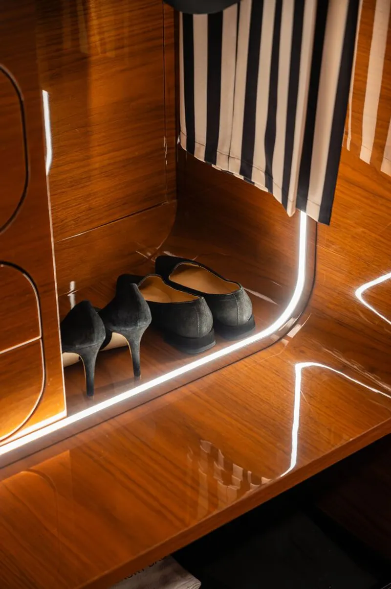 Stepped timber platform with LED strip lighting and ceramic animal figurines beneath vertical slats