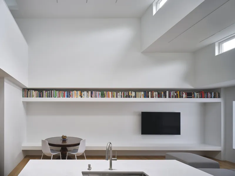 White interior with continuous book ledge above dining area and kitchen counter under clerestory windows
