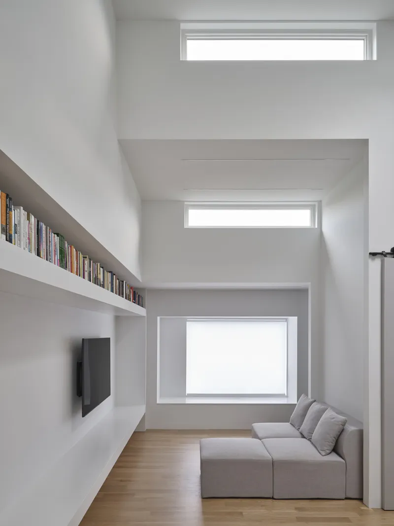 Living room with stacked horizontal windows and built-in bookshelf running beneath the wood floor line