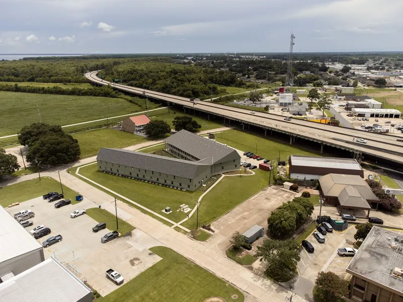 Aerial view of the gabled metal-clad building surrounded by parking lots and an elevated highway
