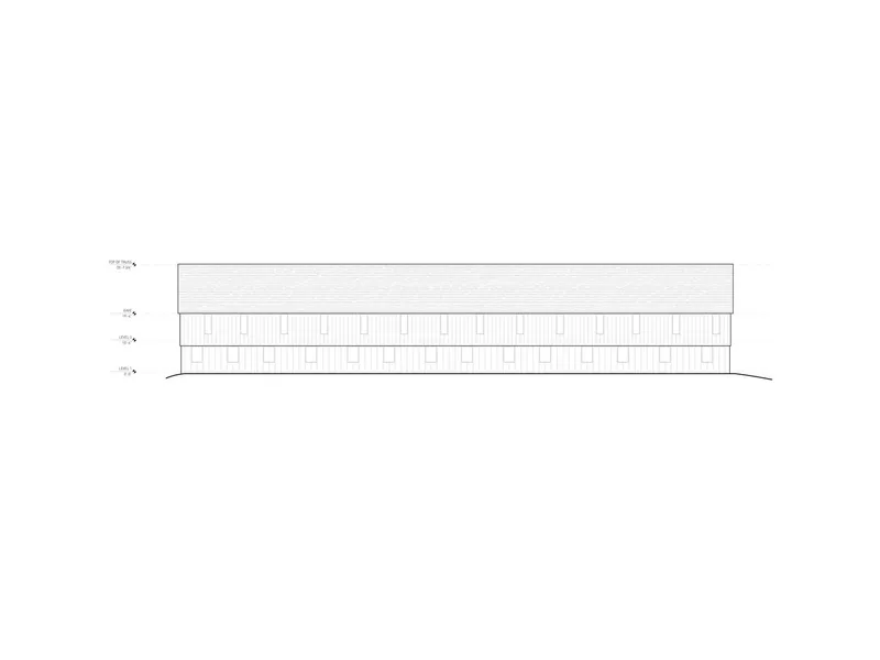 Elevation drawing depicting a long linear building with repeated vertical window openings and gabled roof