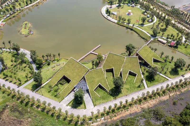 Top-down view of the zigzag planted roof forms with courtyards and water on three sides