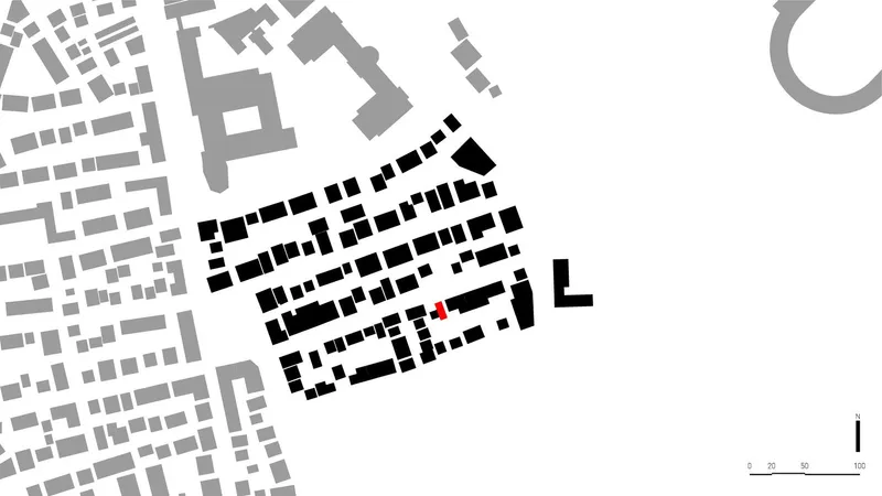 Site plan drawing showing a highlighted building volume within a dense urban block