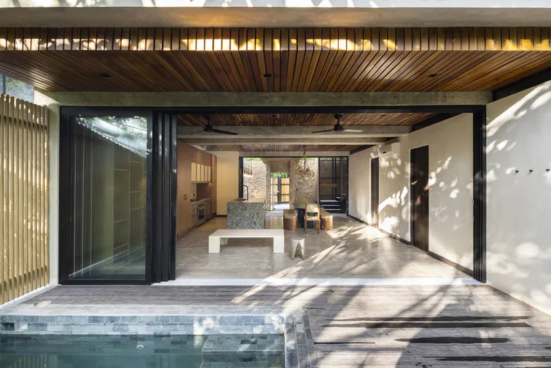 Fully open folding glazed doors connecting the interior living space to the timber deck and pool edge