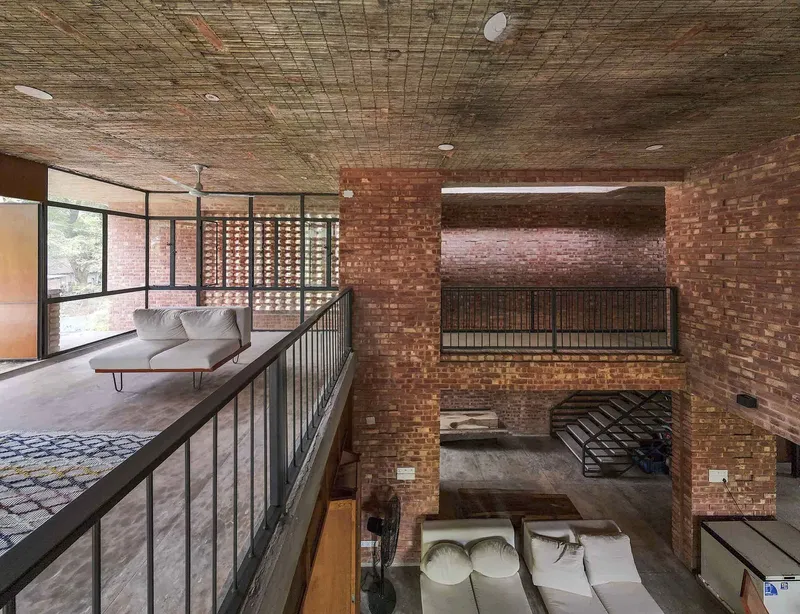 View from mezzanine showing multiple split levels connected by steel railings under a textured bamboo ceiling