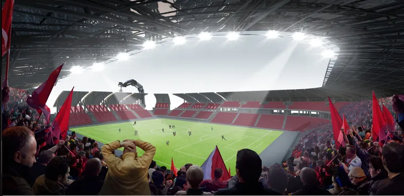 View from the stands showing the pitch and crowd with flags under the open roof