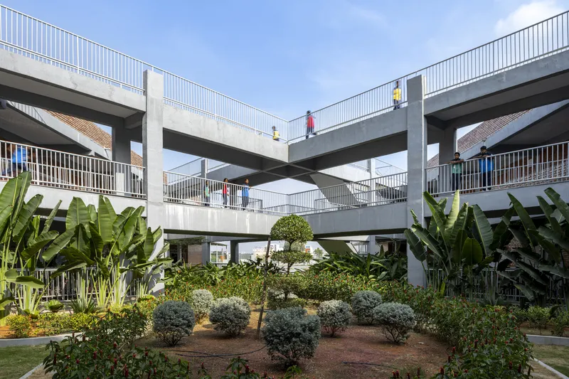 Courtyard garden with banana palms and topiary shrubs surrounded by concrete walkways and railings