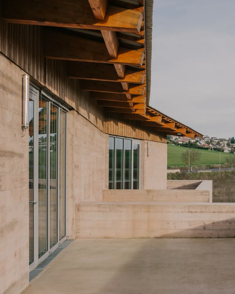 Corner terrace with concrete floor and timber roof soffit overlooking rolling hills and village in distance