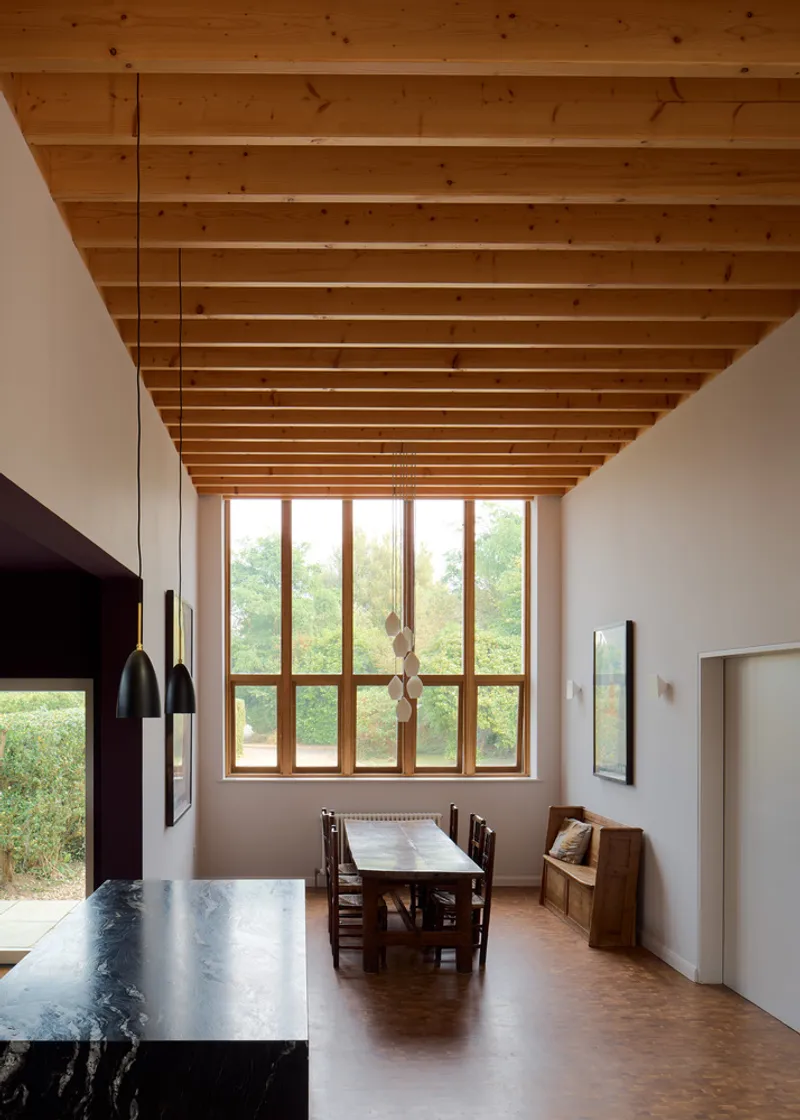 Dining area with exposed timber joist ceiling, tall timber-framed window and pendant lighting