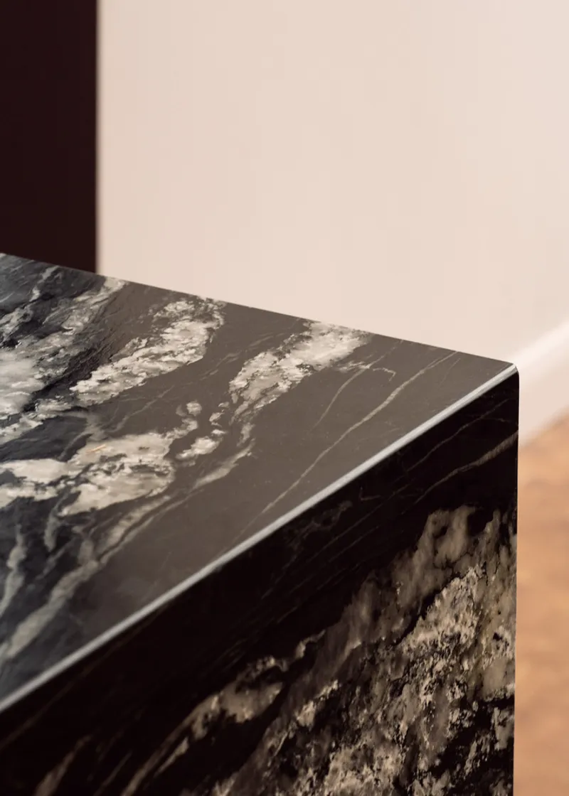 Detail of the marbled stone countertop edge showing white veining against dark background