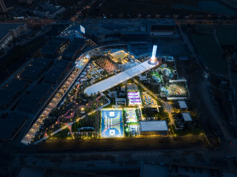 Night aerial view of the illuminated recreational complex and surrounding urban blocks
