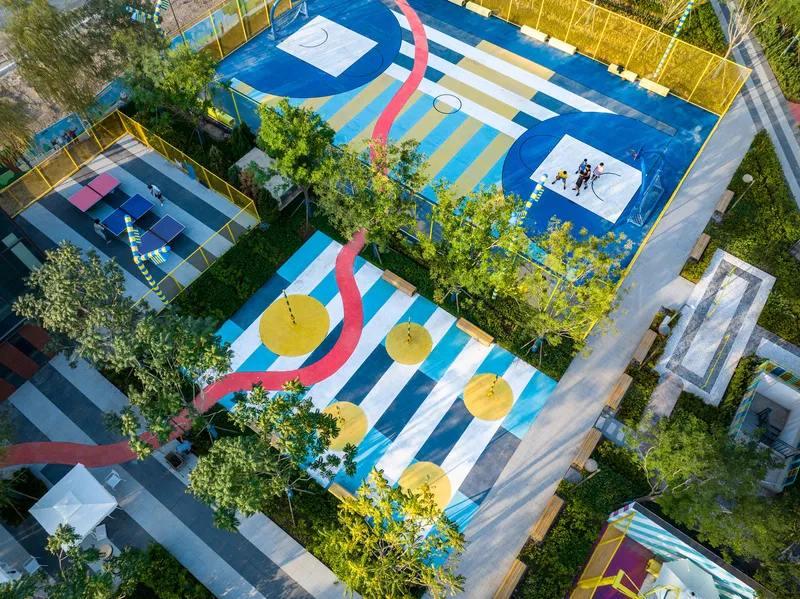 Painted basketball court with blue and yellow striped markings and yellow umbrella canopies