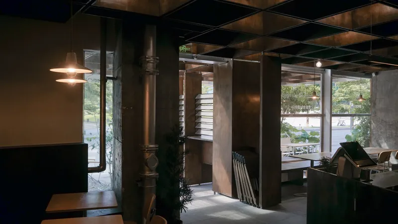 Interior view at dusk showing exposed ductwork, steel columns, and warm lighting through the coffered ceiling