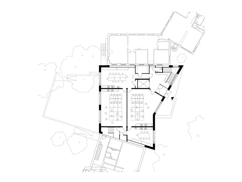 Upper floor plan drawing showing classrooms, central stair, and angled walls meeting at oblique corners