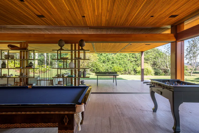 Covered terrace with timber slat ceiling opening to a lawn with trees beyond