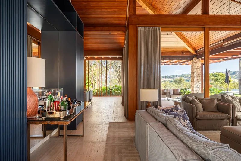 Interior corridor with ribbed dark cabinetry wall and timber ceiling connecting to outdoor terrace