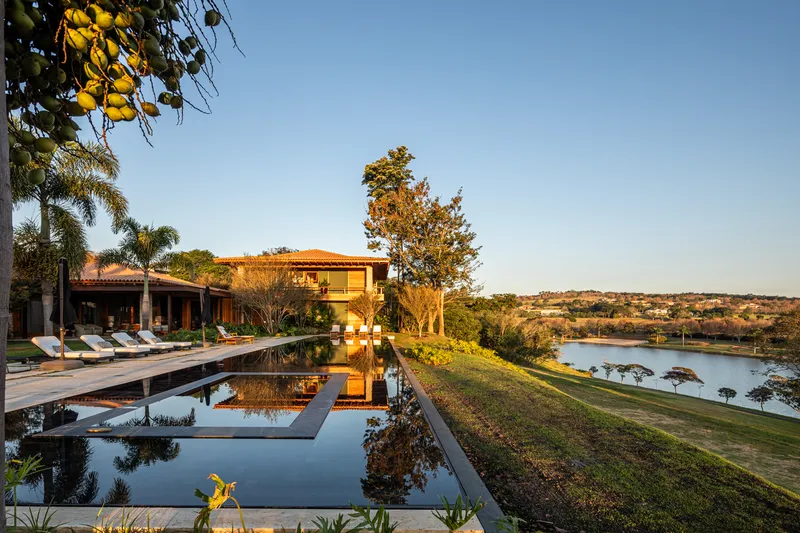 Terraced pool and lawn descending toward the lakeside under a clear evening sky