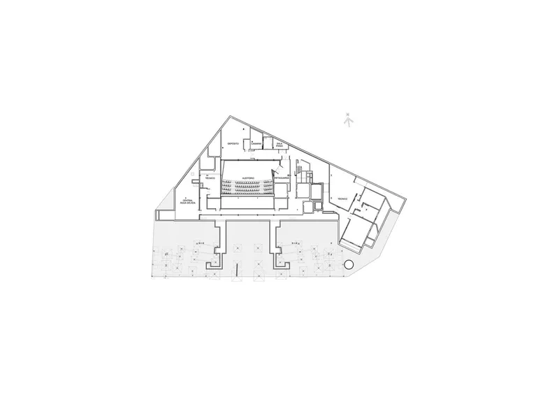 Floor plan showing a triangular footprint with paired courtyards flanking a central auditorium space