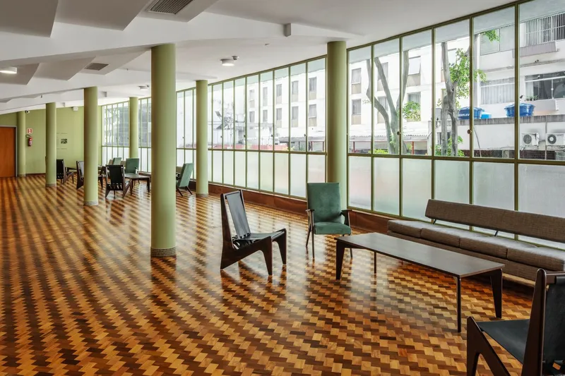 Open foyer with olive columns, checkered tile flooring, and floor-to-ceiling windows overlooking the street