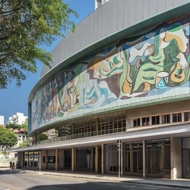 Close view of the curving mosaic mural depicting figures and musical instruments under clear sky