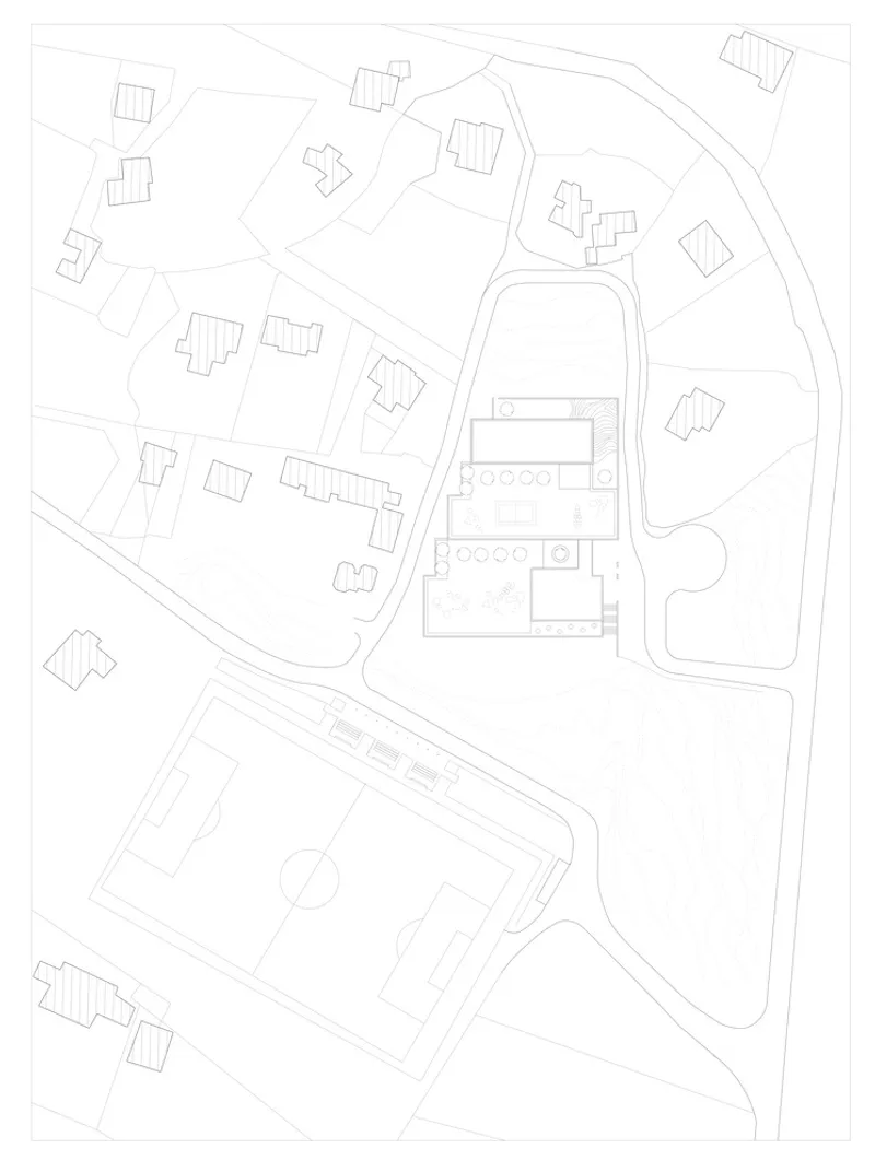 Site plan drawing showing building footprints scattered around a central courtyard and adjacent football pitch