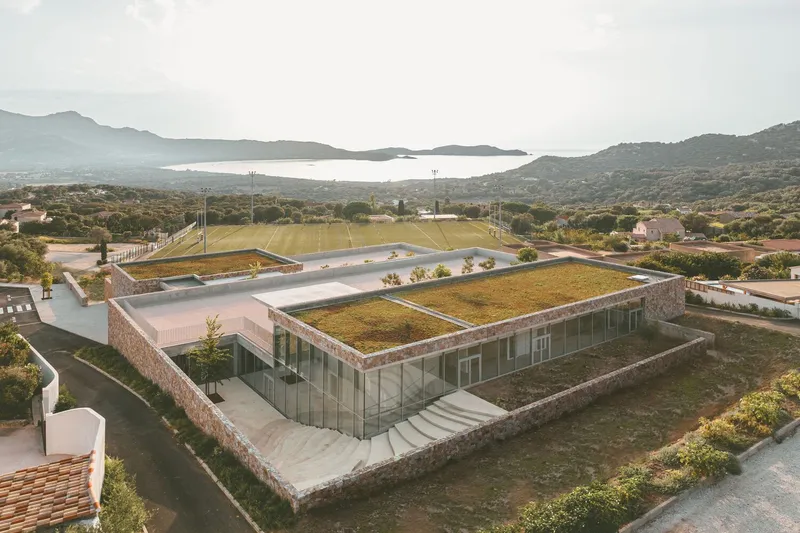 Aerial perspective showing the planted green roof extending over the glass and stone perimeter walls